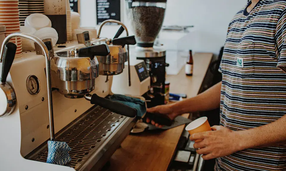 Barista bereitet frischen Espresso an einer Maschine zu